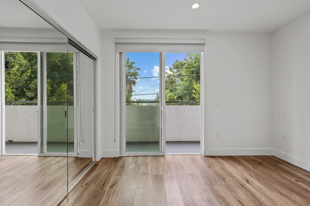 Bedroom with Balcony, Mirrored Closet, Recessed Lighting, and Vinyl Flooring