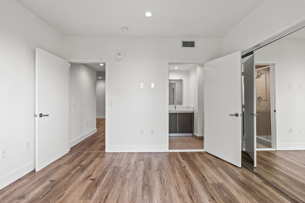 Bedroom with Mirrored Closet, Recessed Lighting, Vinyl Flooring, and Bathroom