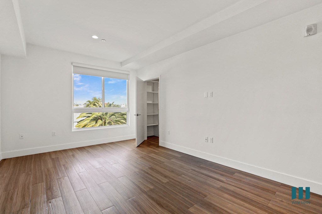 Spacious Bedroom with Vinyl Flooring, Recessed Lighting, and Walk-In Closet with Shelving