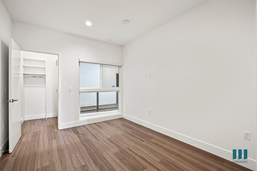 Bedroom with Vinyl Flooring, Walk-In Closet, and Large-Size Windows