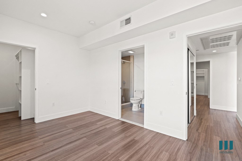 Bedroom with Vinyl Flooring, Recessed Lighting, Walk-In Closet, and Bathroom