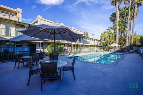 A pool area with chairs and umbrellas is shown.