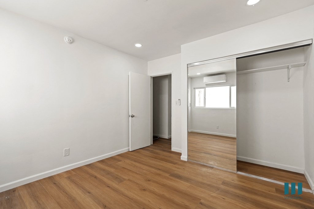 Bedroom with Vinyl Flooring, Recessed Lighting, and Mirrored Closet