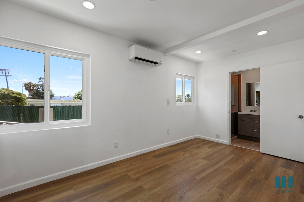 Bedroom with Bathroom, Vinyl Flooring, Recessed Lighting, and Windows