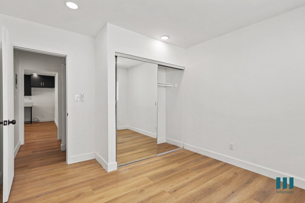Bedroom with Mirrored Closet, Recessed Lighting, and Vinyl Flooring