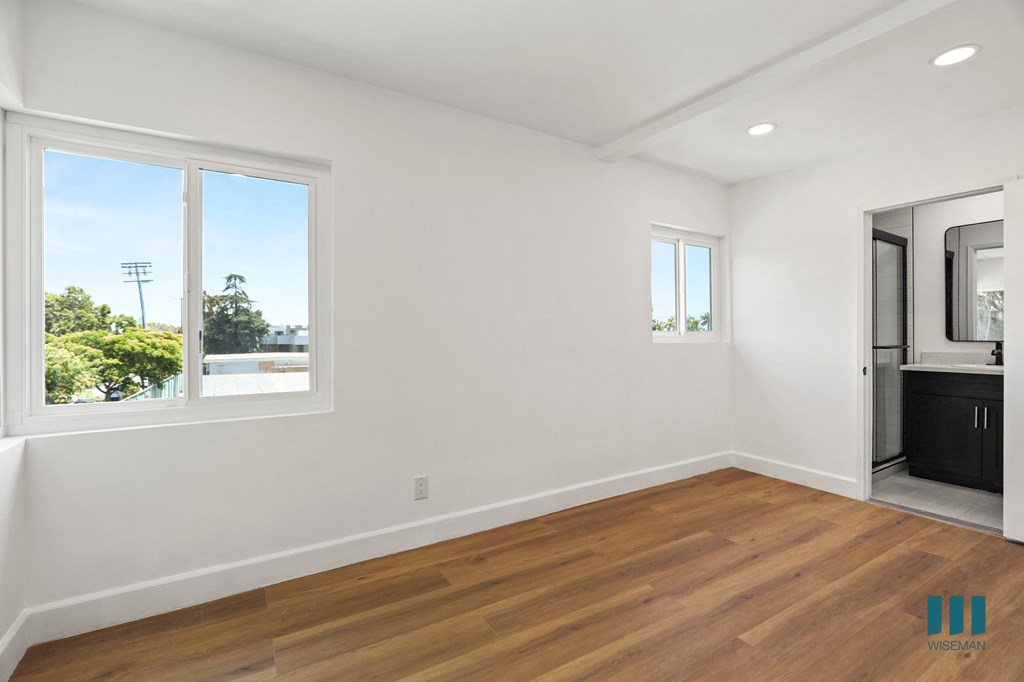 Bedroom with Multiple Windows, Vinyl Flooring, Recessed Lighting, and Bathroom