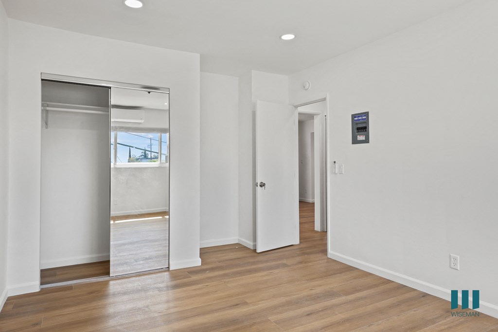 Bedroom with Mirrored Closet and Vinyl Flooring