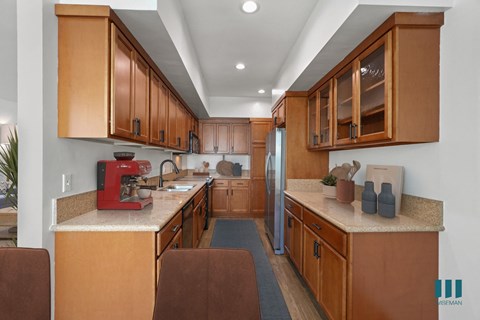 a kitchen with wooden cabinets and granite counter tops and a stove and refrigerator