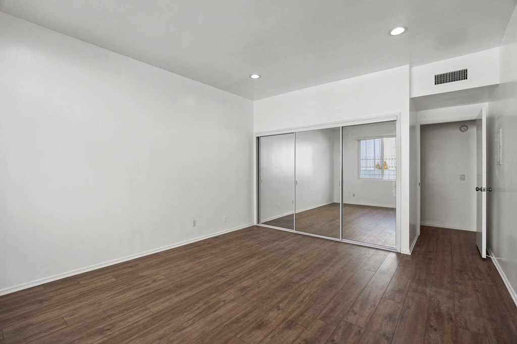 Bedroom with Large-Size Mirrored Closet and Vinyl Flooring
