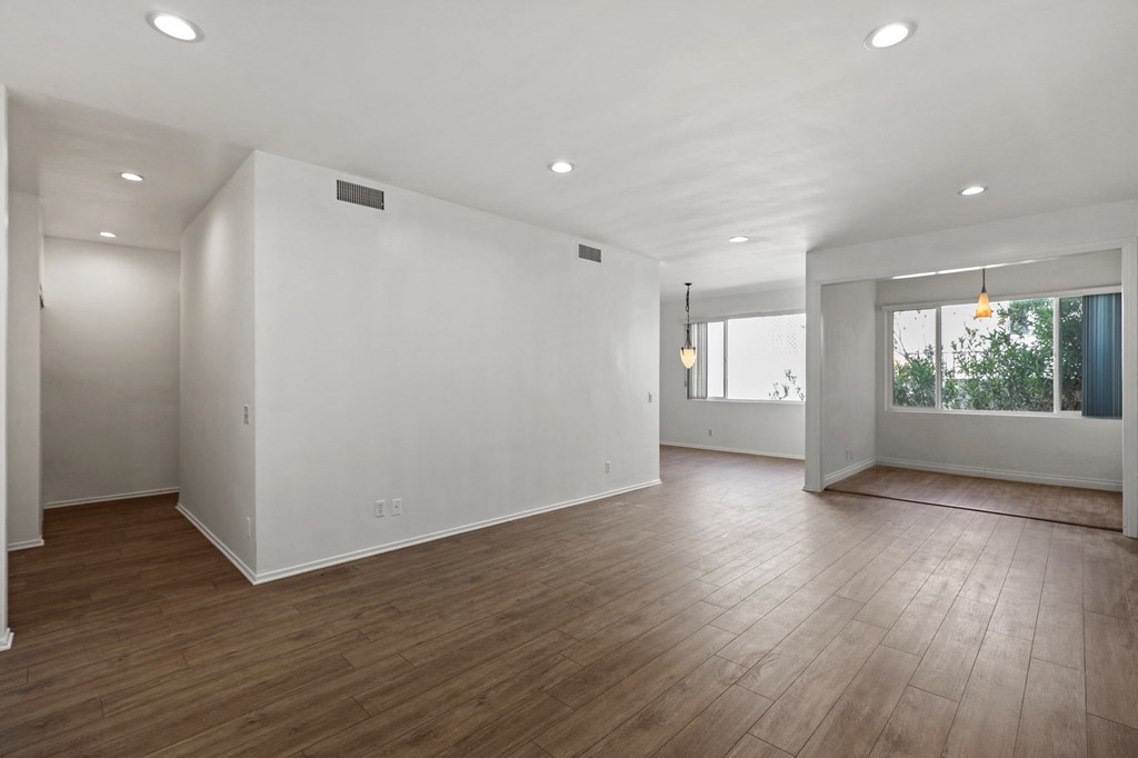 an empty living room with white walls and hardwood floors
