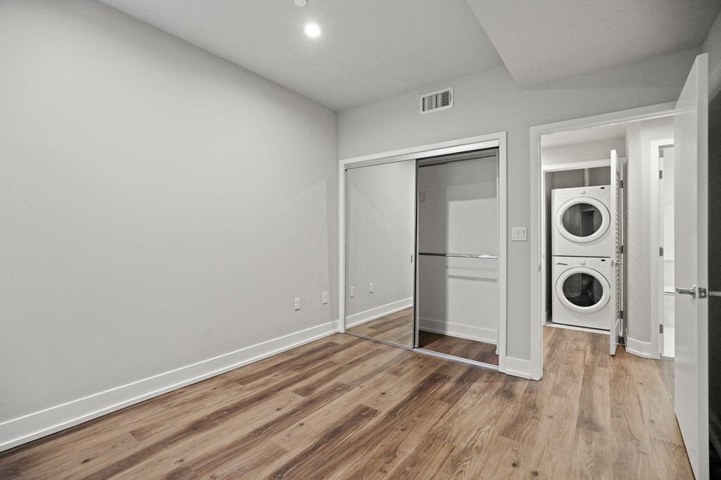 Bedroom with Mirrored Closet and Vinyl Flooring and Hallway with In-Suite Washer & Dryer