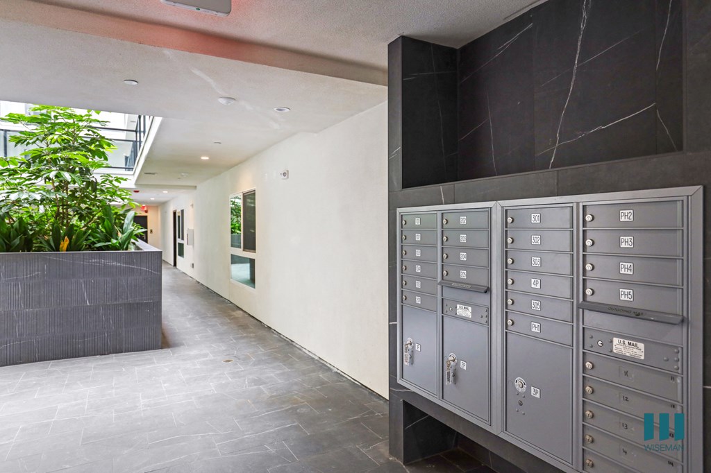 a long hallway with lockers and a plant
