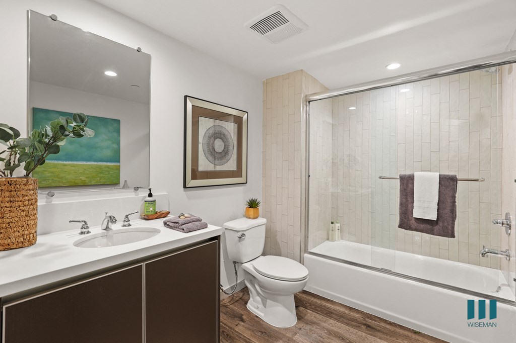 Bathroom with Full-Size Bathtub with Glass Door, and Vanity Cabinet Storage