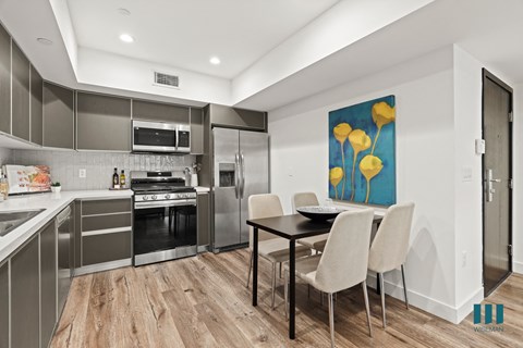 a kitchen with stainless steel appliances and a table with chairs