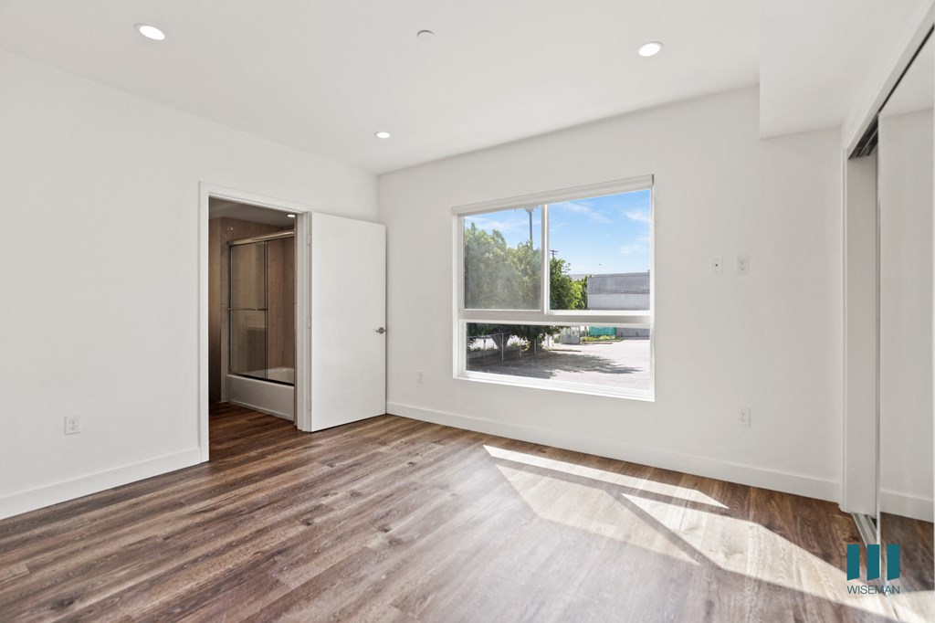 Bedroom with Large Windows, Bathroom, and Mirrored Closet