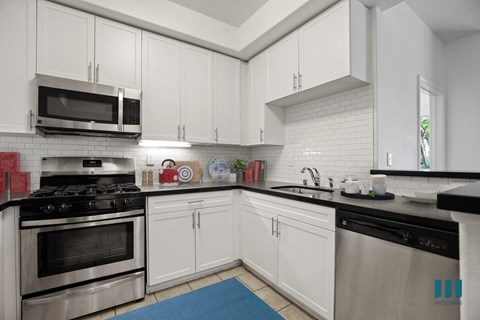 a kitchen with stainless steel appliances and white cabinets