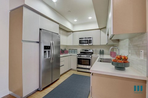 a kitchen with white cabinets and stainless steel appliances