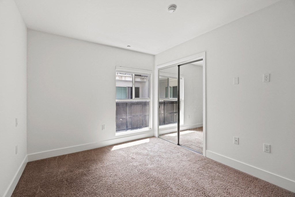 Bedroom with Mirrored Closet and Window
