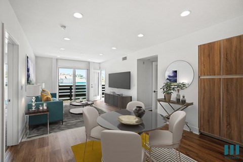 A modern living room with a glass table and white chairs.