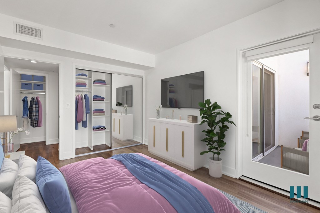 Bedroom with Mirrored Closet with Shelving, Vinyl Flooring, and Patio