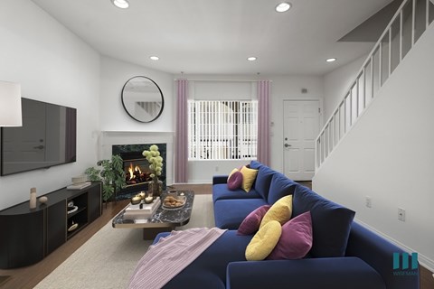 A living room with a blue couch and a fireplace.