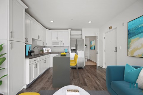 A modern kitchen with white cabinets and a grey island.