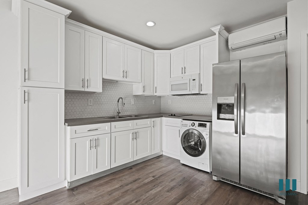 A modern kitchen with white cabinets and stainless steel appliances.