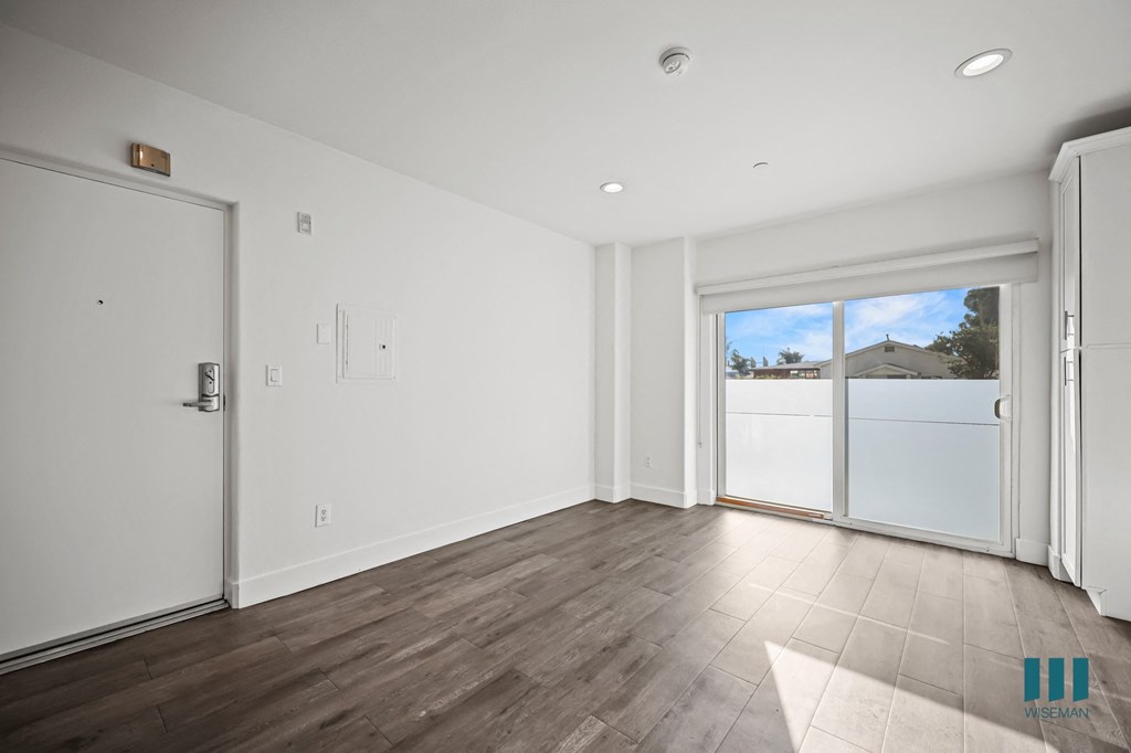 A room with a sliding glass door leading to a backyard.