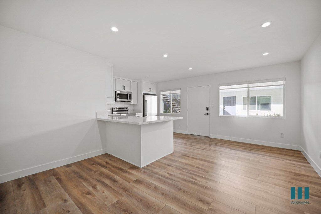 A kitchen with wooden floors and white walls.