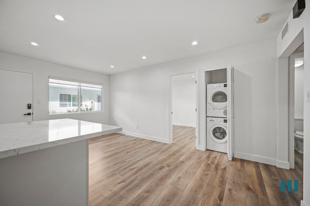 A modern kitchen with a washing machine built into the cabinetry.