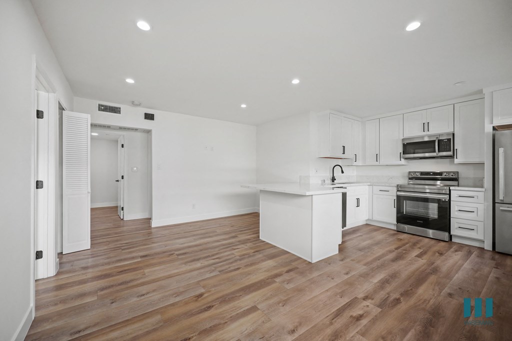 A modern kitchen with white cabinets and stainless steel appliances.
