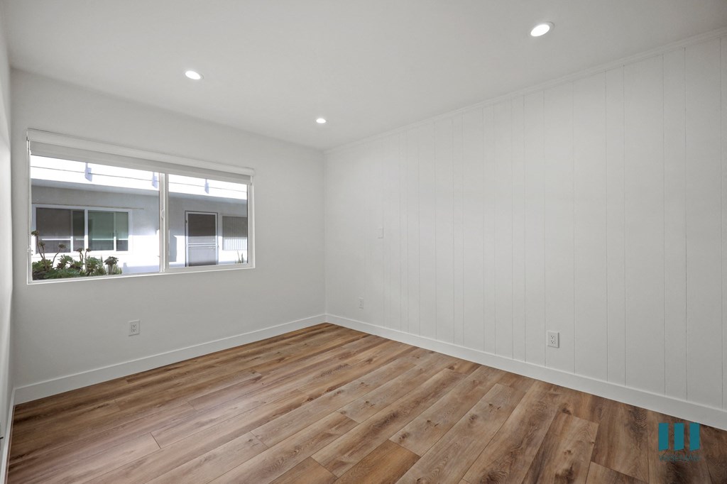 A room with wooden flooring and a window.
