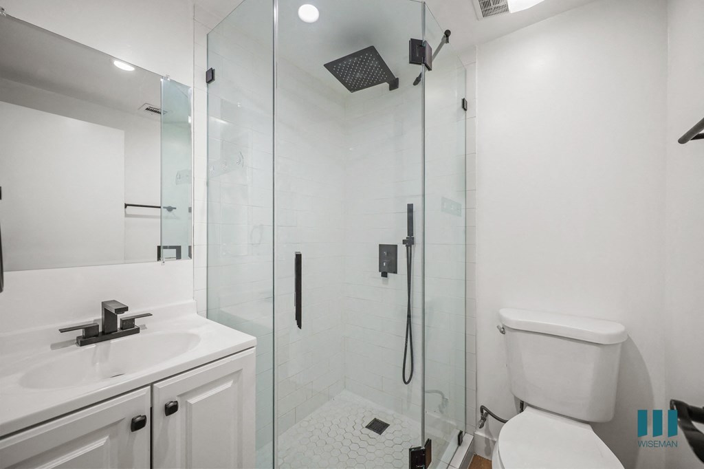A white bathroom with a walk in shower.