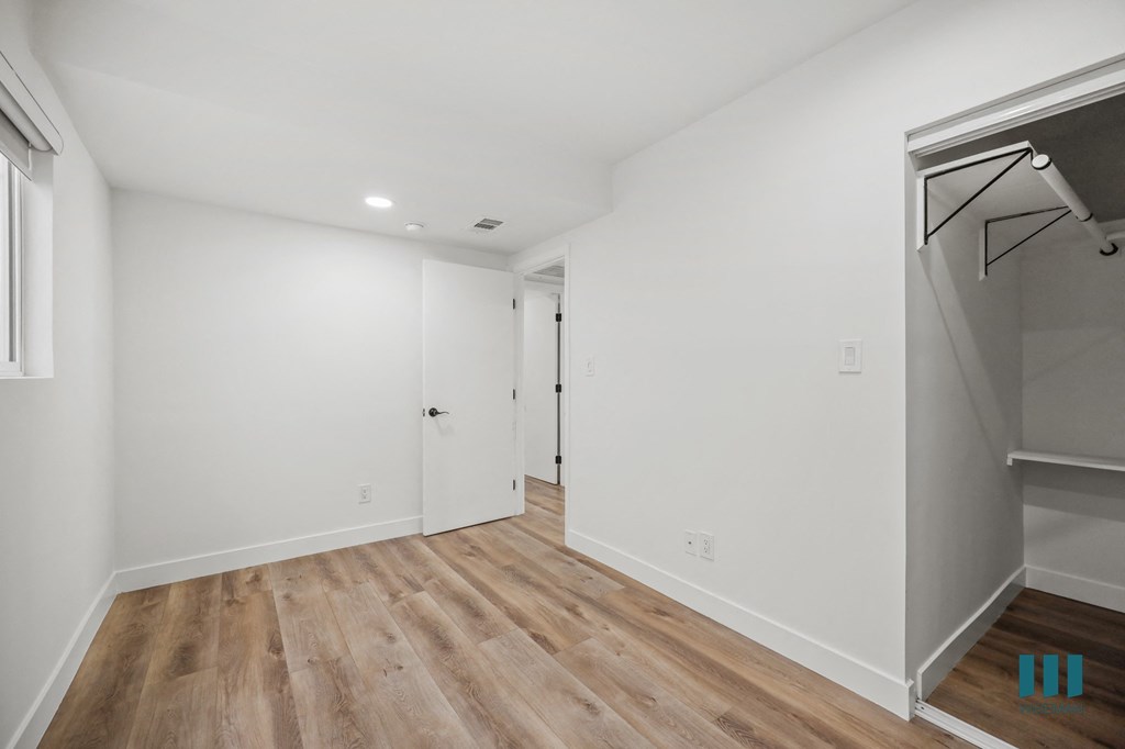 A room with wooden flooring and white walls.