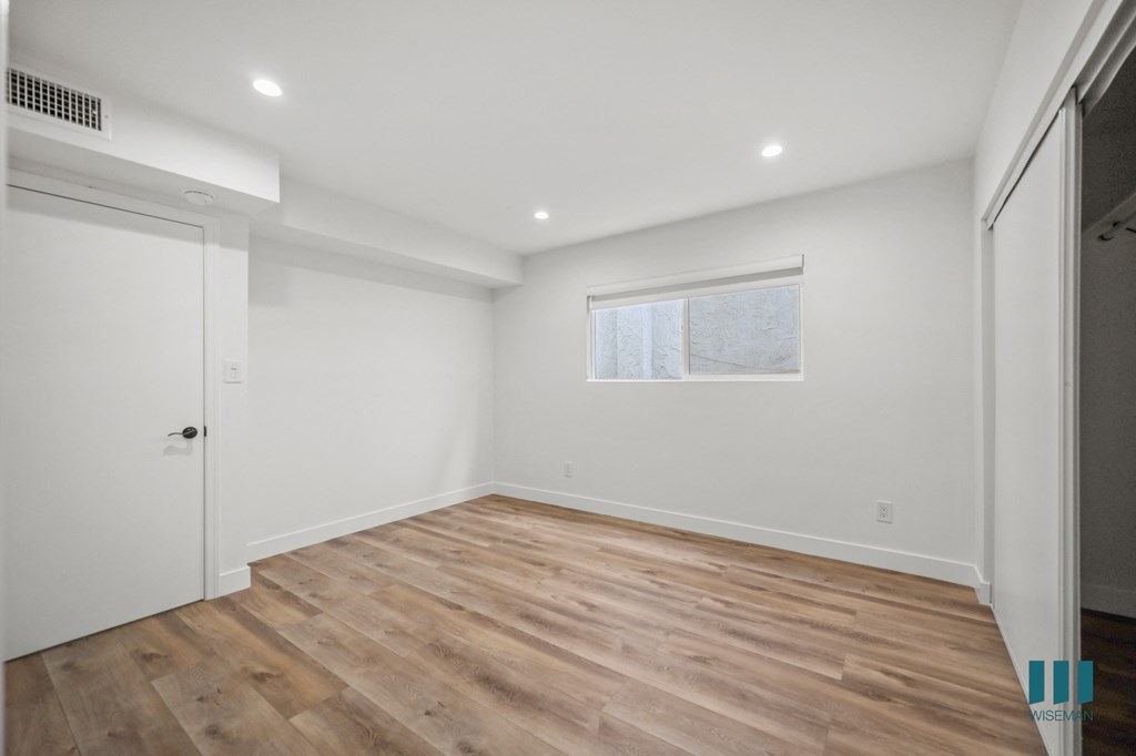 A room with wooden flooring and a window.