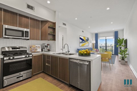 A modern kitchen with a stainless steel refrigerator and a yellow rug on the floor.