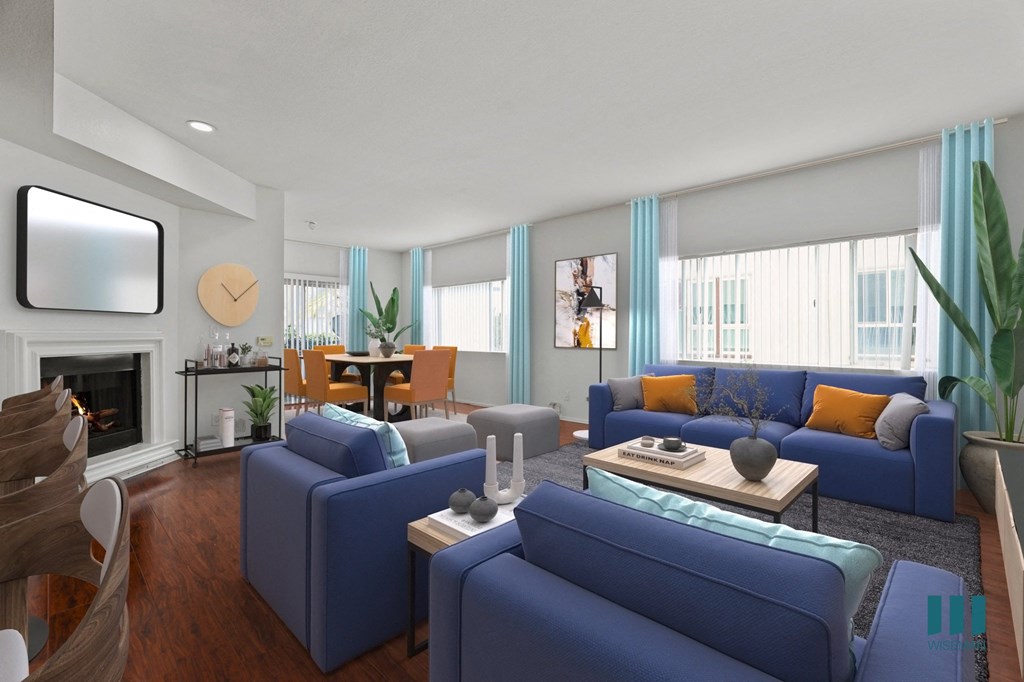 A living room with blue couches and a fireplace.