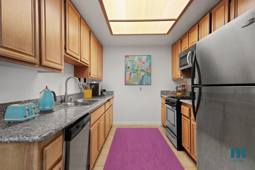 A kitchen with wooden cabinets and a black refrigerator.
