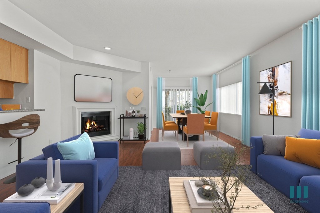A modern living room with a fireplace and blue couches.