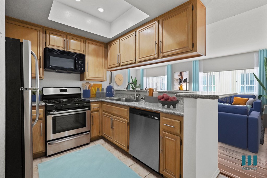 A kitchen with wooden cabinets and a black refrigerator.