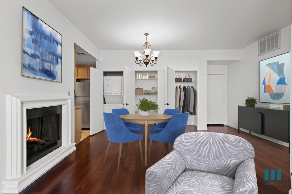 A living room with a fireplace and a dining table with chairs.