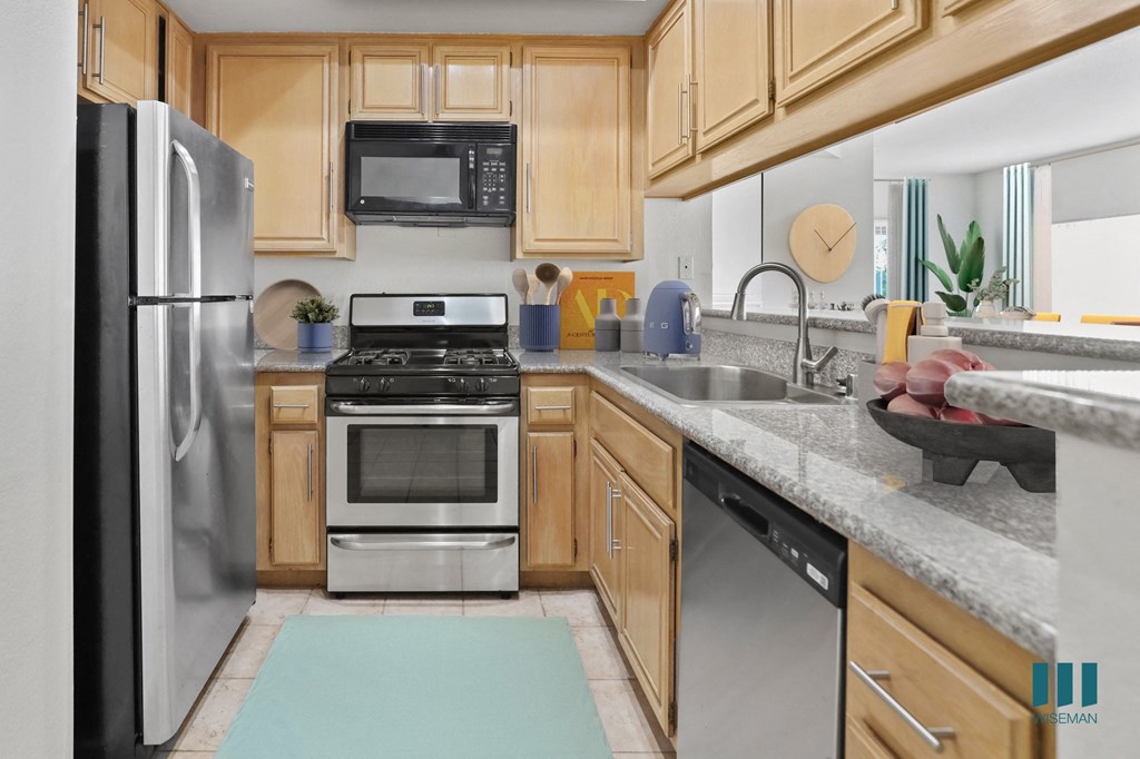 A kitchen with wooden cabinets and stainless steel appliances.