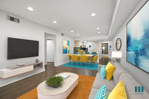 A modern living room with a grey sofa, yellow chairs, and a large painting on the wall.
