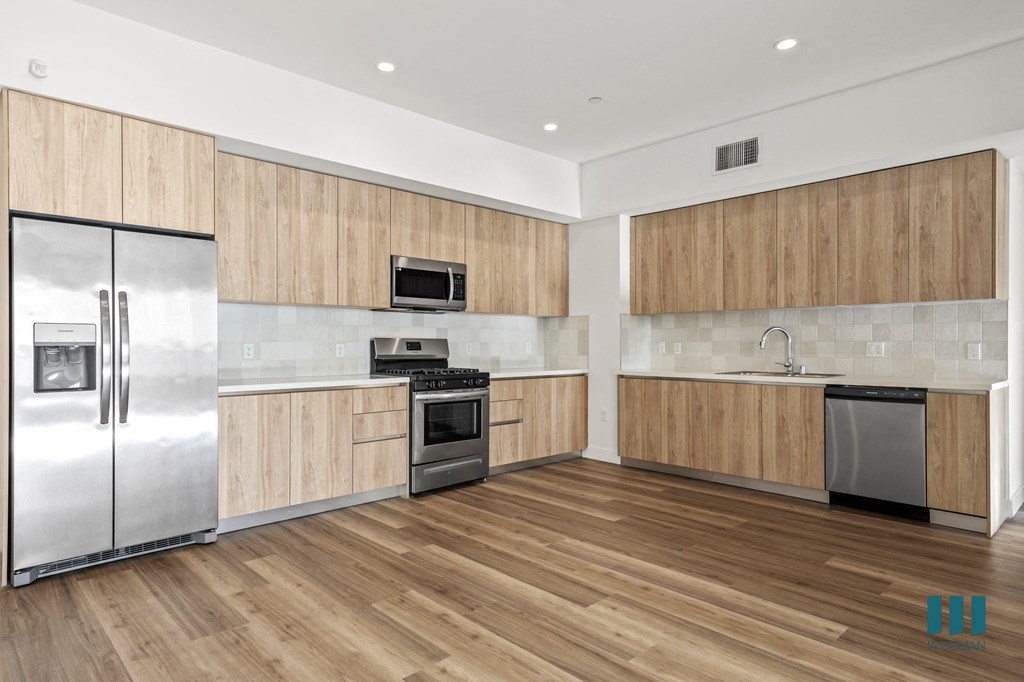 A modern kitchen with wooden cabinets and stainless steel appliances.