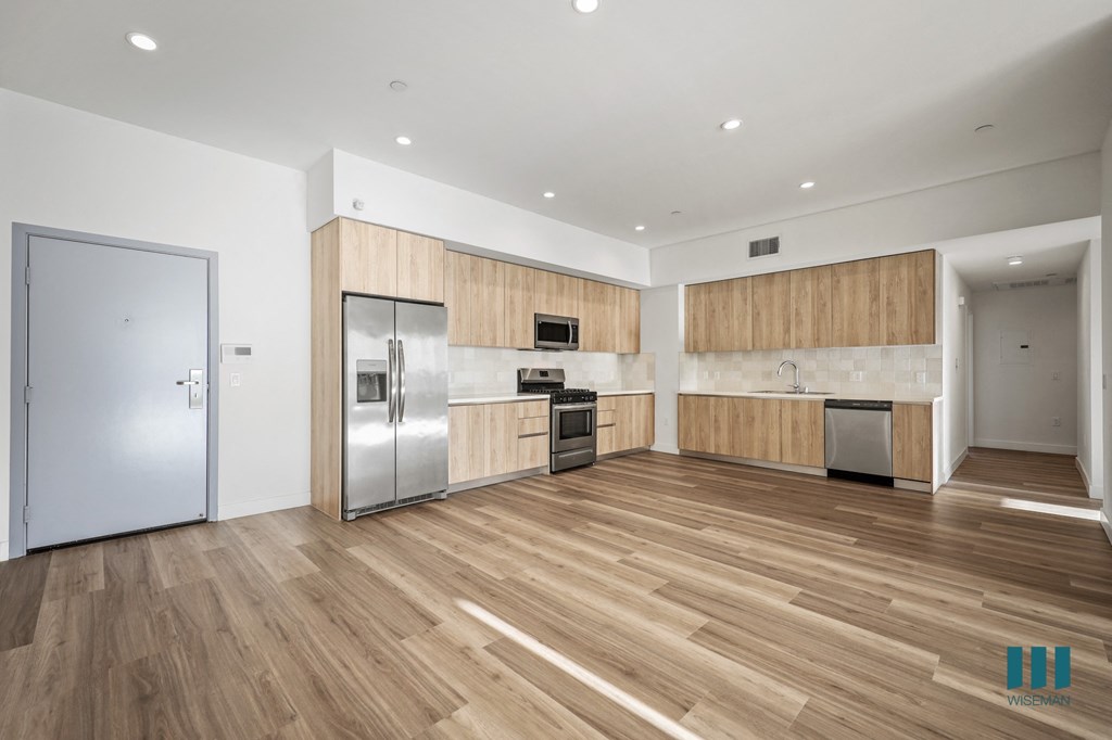 A kitchen with wooden floors and stainless steel appliances.