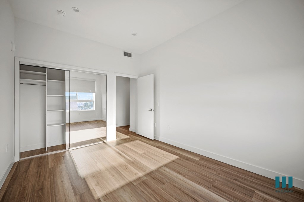 A room with a white wall and a wooden floor.