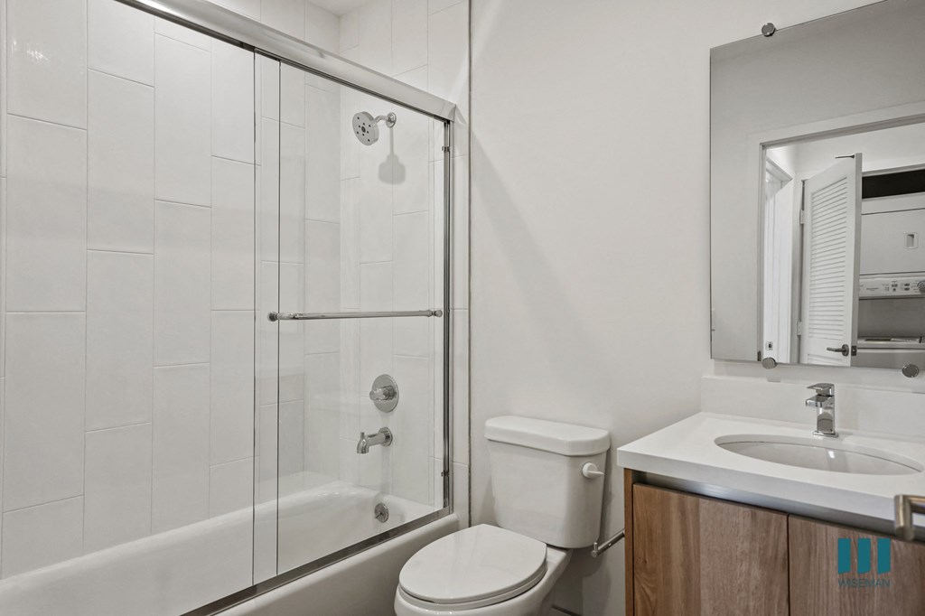 A white toilet sits next to a sink in a bathroom.