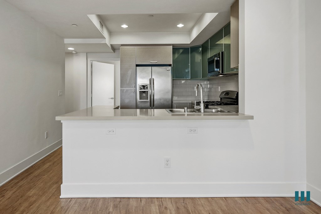 A modern kitchen with a white island and stainless steel appliances.