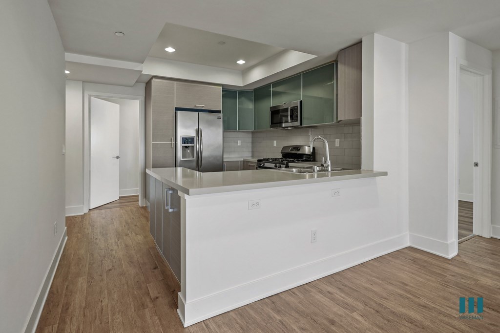 A modern kitchen with white cabinets and stainless steel appliances.