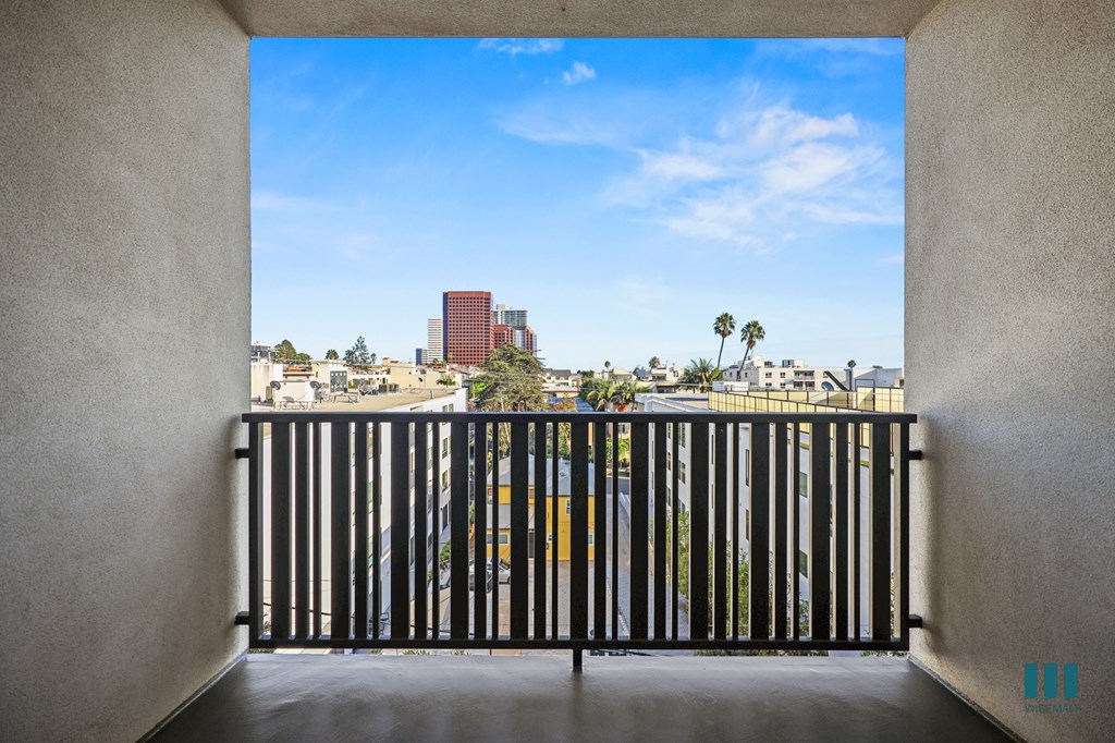 A view from a balcony looking out at a cityscape.